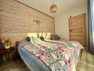 a bedroom with a bed with a wooden wall at Villa Corvo Bianco in Sidzina
