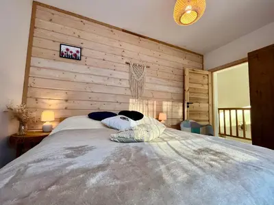 a bedroom with a large bed with wooden walls at Villa Corvo Bianco in Sidzina