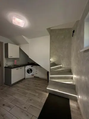 a stairway in a room with a kitchen and a kitchenstration at Apartament Guziczek2 in Nowy Targ