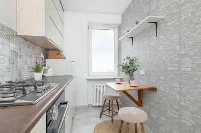 a kitchen with a counter and a table with stools at Minimalist One Bedroom Apartment in Kraków Near Wawel by Noclegi Renters in Kraków