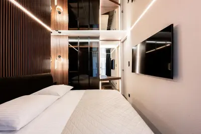 a bedroom with a white bed and a television at Native Apartments Kościuszki 39/28 in Kraków