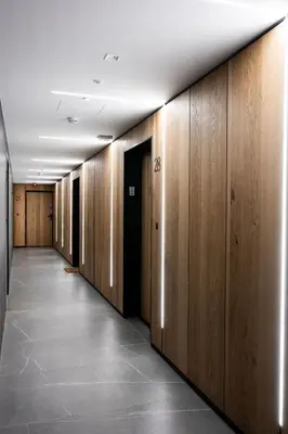 a hallway with wooden walls and a hallway with a row of doors at Native Apartments Kościuszki 39/28 in Kraków
