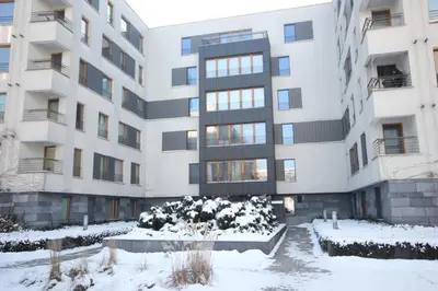 an apartment building with snow in front of it at VIVA GREEN & NATUR Apt close to Vistula River - by Homelike Krakow in Kraków