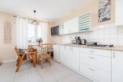 a kitchen with white cabinets and a table and chairs at Kraków Eagle Pharmacy Studio by Noclegi Renters in Kraków