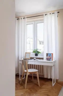 a white desk with a chair in front of a window at Kraków Eagle Pharmacy Studio by Noclegi Renters in Kraków