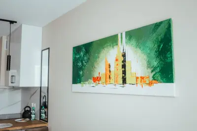 a television hanging on a wall in a kitchen at Nowy Złocień Comfort Apartment by BookingHost in Kraków