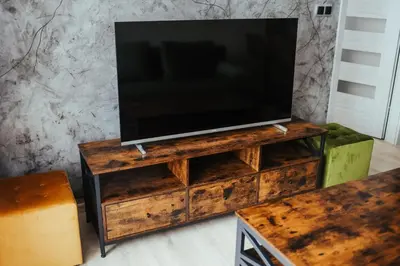 a tv on a wooden stand with a tv on top at Nowy Złocień Comfort Apartment by BookingHost in Kraków