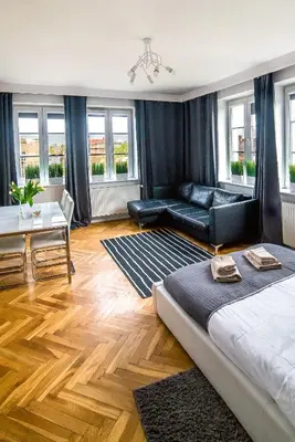 a living room with a bed and a couch and a table at Cracovia Apartments in Kraków