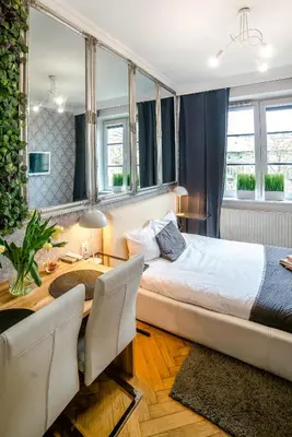 a bedroom with a bed and a table and chairs at Cracovia Apartments in Kraków