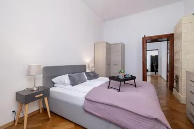 a bedroom with a bed and a side table with a mirror at Spacious, 2 Bedrooms Apartment Cracow City Centre by Noclegi Renters in Kraków