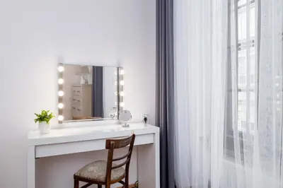 a bathroom with a vanity with a mirror and a chair at Spacious, 2 Bedrooms Apartment Cracow City Centre by Noclegi Renters in Kraków
