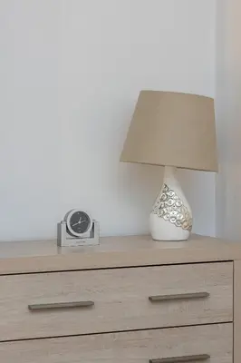 a lamp sitting on top of a dresser with a clock at Spacious, 2 Bedrooms Apartment Cracow City Centre by Noclegi Renters in Kraków