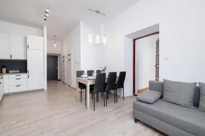 a living room with a couch and a table and chairs at Spacious, 2 Bedrooms Apartment Cracow City Centre by Noclegi Renters in Kraków