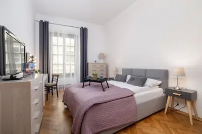 a bedroom with a bed and a dresser with a tv at Spacious, 2 Bedrooms Apartment Cracow City Centre by Noclegi Renters in Kraków