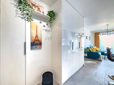 a living room with white walls and a sliding door at Apartament Filmowej Magii w centrum Krakowa in Kraków