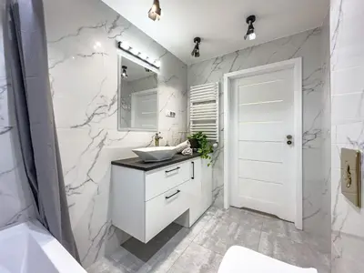 a white bathroom with a sink and a mirror at Apartament Filmowej Magii w centrum Krakowa in Kraków
