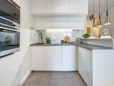 a white kitchen with white cabinets and appliances at Apartament Filmowej Magii w centrum Krakowa in Kraków