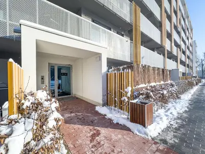 a fence in front of a building in the snow at Apartament Filmowej Magii w centrum Krakowa in Kraków