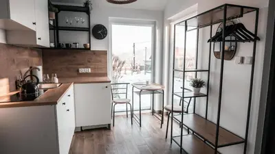 a kitchen with white cabinets and a table and stools at Pokój Dziupla in Tarnawa Dolna