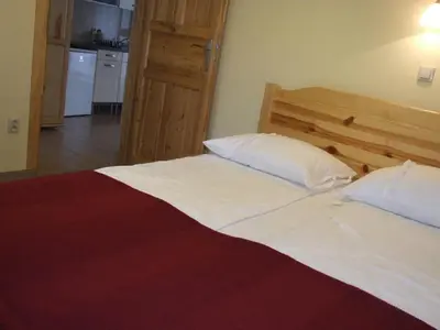 a large bed with white sheets and pillows in a bedroom at Pokoje i apartamenty pod Jaworzyną w Koninkach in Koninki