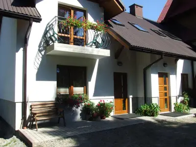 a building with a bench and a balcony at Pokoje i apartamenty pod Jaworzyną w Koninkach in Koninki