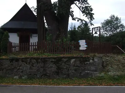 a sign in front of a house with a fence at Pokoje i apartamenty pod Jaworzyną w Koninkach in Koninki