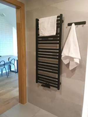 a towel rack with towels hanging on a wall at MODRZEW - noclegi w Pyzówce in PyzÃ³wka