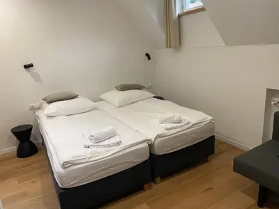 a bed in a room with white sheets and pillows at MODRZEW - noclegi w Pyzówce in PyzÃ³wka