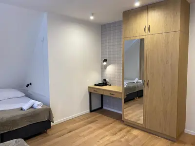 a bedroom with a mirror and a bed and a desk at MODRZEW - noclegi w Pyzówce in PyzÃ³wka