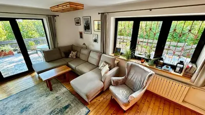 a living room with a couch and chairs and windows at Przystanek Zawadka in Zawadka