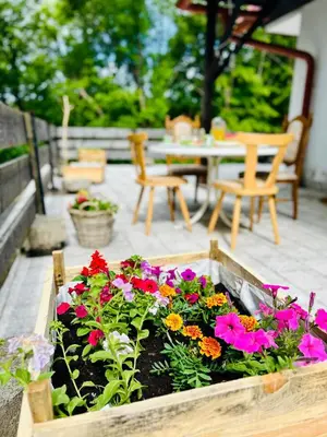 a wooden box filled with colorful flowers on a patio at Przystanek Zawadka in Zawadka
