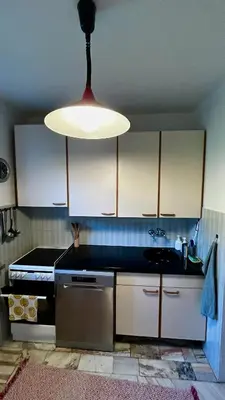 a kitchen with a large light hanging from the ceiling at Przystanek Zawadka in Zawadka