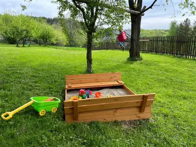 a wooden sandbox with toys in it in a park at Przystanek Zawadka in Zawadka