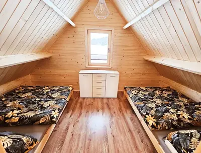 two beds in a room with wooden walls at Sielanka u Basi in Toporzysko