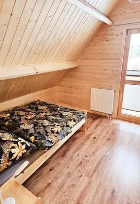a bedroom with a bed in a room with wooden walls at Sielanka u Basi in Toporzysko