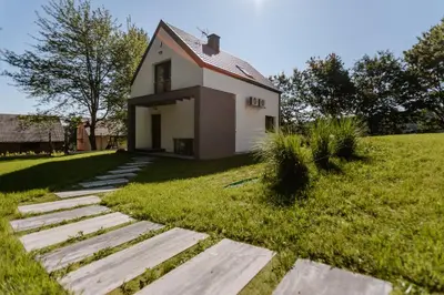 a small white house with a grassy yard at Tarnova Chill in Tarnawa