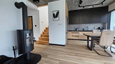 a kitchen and dining room with a wood burning stove at Tarnova Chill in Tarnawa