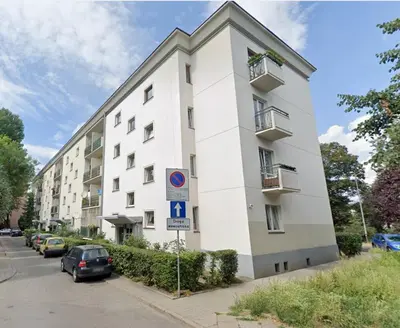 a white building with cars parked in front of it at Blachnickiego 9 by Homeprime in Kraków
