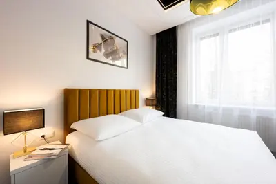 a bedroom with a large white bed and a window at Native Apartments Słowackiego 14 Superior in Kraków