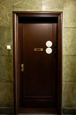 a brown elevator door with two signs on it at Native Apartments Słowackiego 14 Superior in Kraków