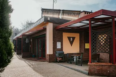 a brick building with a balcony and a table at Apartamenty Pod Dzwonkiem in Wadowice