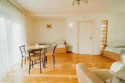 a room with a table and chairs and a bedroom at Apartamenty Pod Dzwonkiem in Wadowice