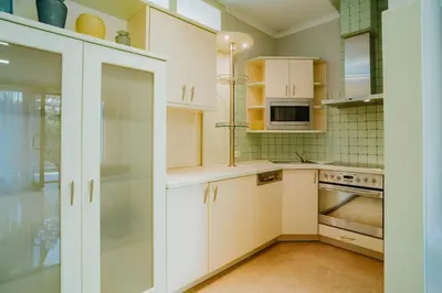 a white kitchen with white cabinets and a sink at Apartamenty Pod Dzwonkiem in Wadowice