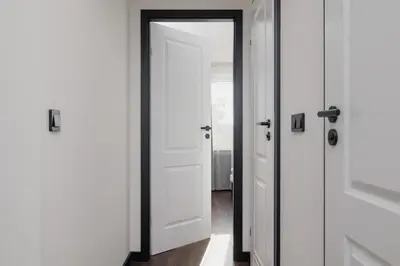 a white door with black trim in a hallway at Comfortable Two-Bedroom Apartment Strzelców by Noclegi Renters in Kraków