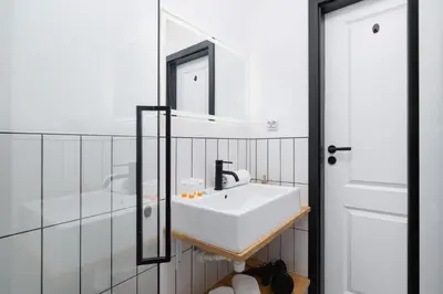a bathroom with a white sink and a mirror at Comfortable Two-Bedroom Apartment Strzelców by Noclegi Renters in Kraków
