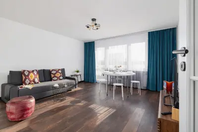 a living room with a couch and a table at Comfortable Two-Bedroom Apartment Strzelców by Noclegi Renters in Kraków
