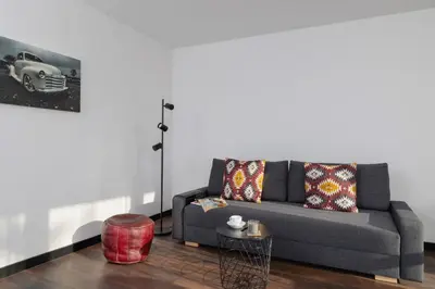 a living room with a couch and a table at Comfortable Two-Bedroom Apartment Strzelców by Noclegi Renters in Kraków