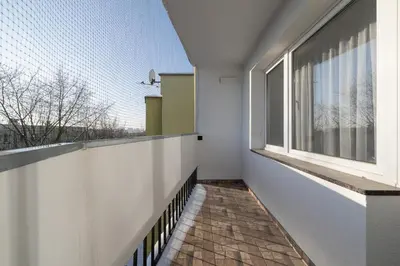 a balcony with a window and a brick floor at Comfortable Two-Bedroom Apartment Strzelców by Noclegi Renters in Kraków