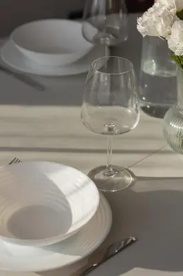 a table with white plates and a wine glass at Comfortable Two-Bedroom Apartment Strzelców by Noclegi Renters in Kraków