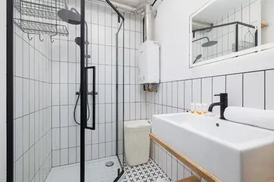 a bathroom with a sink and a shower at Comfortable Two-Bedroom Apartment Strzelców by Noclegi Renters in Kraków